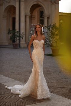 a woman in a wedding dress is standing outside