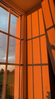 the shadow of a person standing on a window sill in front of an orange wall