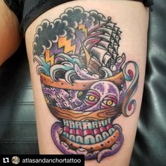 a tattoo with an octopus and ship on it's thigh, in the shape of a bowl