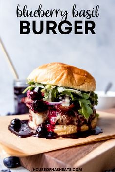 a burger with blueberry sauce and lettuce on a cutting board