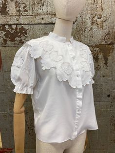 "Homemade Vintage Blouse. It's hard to date this shirt as I think it's been made from re-purposed fabric.  It has short, puff sleeves and a lovely decorative yoke with cutwork & embroidery details.  Please see the measurements below and compare with an item that you already own:  Bust 38\" Underarm to underarm 19\"  Nape of neck to hem 22\" Shoulder to Shoulder 16\" Excellent vintage condition. If you have any questions or require any additional photos, please don't hesitate to contact me. All i Fitted Embroidered Tops With Puff Sleeves, Cotton Embroidered Puff Sleeve Blouse, Fitted Cotton Embroidered Top With Puff Sleeves, Fitted Broderie Anglaise Short Sleeve Top, Fitted Collar Top With Broderie Anglaise, Fitted Short Sleeve Top With Broderie Anglaise, Cotton Puff Sleeve Top With Floral Embroidery, Vintage Puff Sleeve Top With Floral Embroidery, Vintage Floral Embroidered Puff Sleeve Top