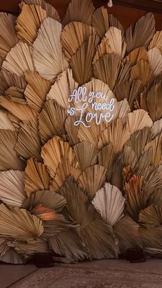 an arrangement of folded paper flowers with the words all you need is love