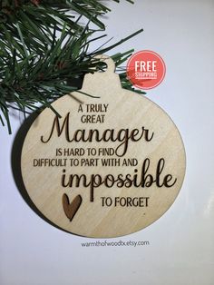 a wooden ornament hanging from a christmas tree with the words, a truly great manager is hard to find and difficult to