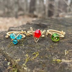 three different colored rings sitting on top of a rock