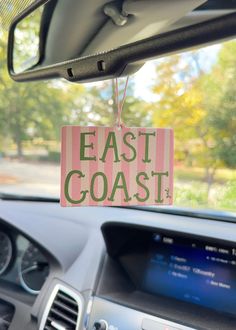 an east coast sign hanging from the dashboard of a car