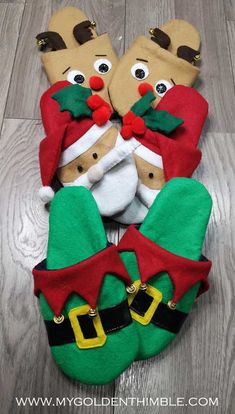 christmas socks with santa claus and reindeer faces on them sitting on the floor next to each other