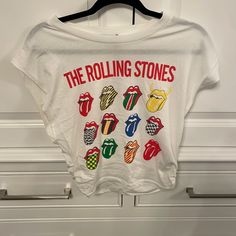 the rolling stones t - shirt hanging on a white door with checkerboard stickers