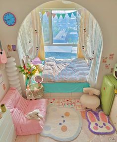 a bedroom with an arched window and rugs on the floor is decorated in pastel colors