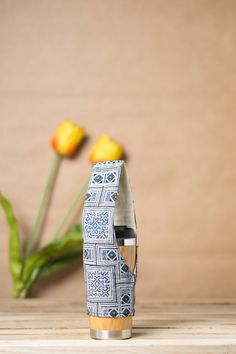 two yellow tulips are in the background and one is on a wooden table