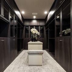 a large walk in closet filled with lots of brown and white furniture, including a bench