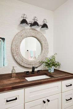 a bathroom with a sink, mirror and towel rack on the wall above it's counter