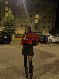 a woman standing in the middle of an empty parking lot at night with her cell phone up to her ear