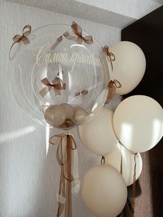 balloons are tied to the back of a clear balloon holder with brown ribbon and bow