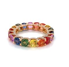 a multicolored ring with diamonds on it's sides and the center surrounded by smaller colored stones