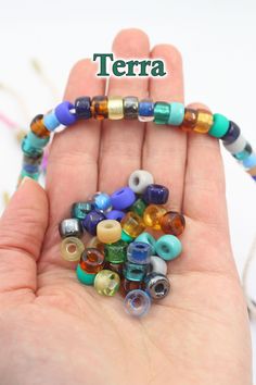 there is a hand that has some beads on it and the words terra in front of it