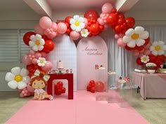 a pink and red birthday party with balloons, flowers and cake on the table in front of it