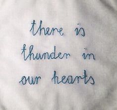 there is thunder in our hearts embroidered on the back of a white shirt with blue writing