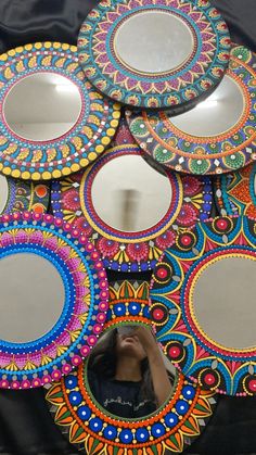 a woman taking a photo of some colorful mirrors