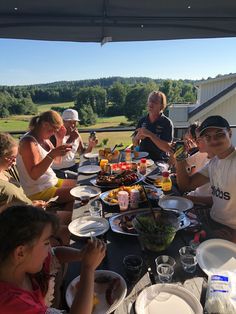 a group of people sitting around a table eating food