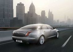 a silver car is driving down the road in front of some tall buildings and skyscrapers