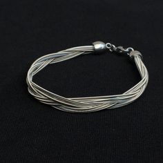 a silver bracelet on a black background