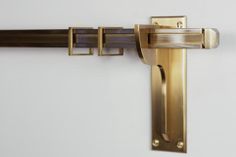 a close up of a door handle on a white wall with a black and gold color