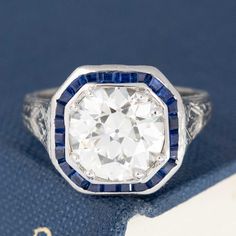 Only beyond obsessed with this antique target ring, set with a gorgeously faceted old European cut diamond, sparkling brightly against the velvety blue sapphires. Highly sogt after, this would make for a true one of a kind engagement ring (plus, she looks like a million bucks on the finger!). Platinum Size 4 & resizable Diamond measures 8.61 - 8.71 x 5.45 mm GIA link here Video Below Octagon Brilliant Cut Sapphire Ring For Anniversary, Anniversary Octagon Brilliant Cut Sapphire Ring, Vintage Diamond White Sapphire Jewelry, Vintage Sapphire Gemstone Diamond Ring, Heirloom Sapphire Ring In Diamond White With Round Cut, Heirloom Sapphire Diamond Ring, Vintage Diamond White Gemstone Ring, Vintage Blue Diamond Ring With Single Cut Diamonds, Vintage Sapphire Diamond Ring With Single Cut Diamonds