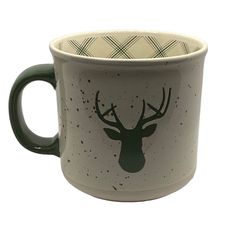 a white and green coffee cup with a deer's head on the inside of it