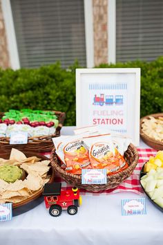 a table topped with lots of food next to a red and white checkered table cloth