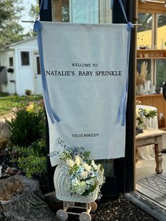 a welcome sign for natalie's baby sprinkle in front of a house