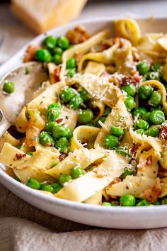 a white bowl filled with pasta and peas