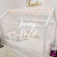 a white bed sitting in a bedroom next to a wallpaper covered with pink flowers