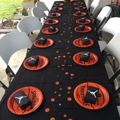 a long table with black and orange plates on it