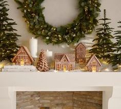 a fireplace decorated with christmas decorations and lit candles