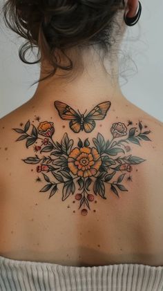 the back of a woman's neck with flowers and butterflies on it