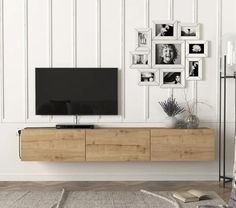 a modern living room with white walls and wood furniture, including a large flat screen tv