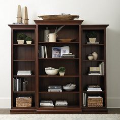 a bookcase with many books and baskets on it