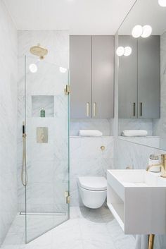 a white bathroom with marble walls and floor