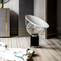 a large white bowl sitting on top of a wooden floor next to a tall mirror