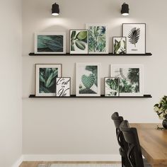 a dining room table with black chairs and framed pictures on the wall above it,