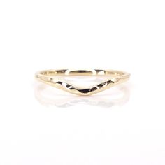 the gold chevron ring is shown on a white surface with an oval shaped band