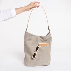 Large linen bag with exterior pockets and a wide leather strap. Handmade with a very light beige rustic linen. It is a bag with a large capacity but lightweigt, designed to go to work, school and for day to day. With a timeless minimalist style. The bag is lined with cotton fabric, two inside pockets, one of them with a zipper. It closes with a zipper (not with a magnet as you see in the photo)and double outside pocket. Removable wide leather strap available in 3 colours. By removing the strap, Everyday Crossbody Hobo Bag With Pockets, Taupe Leather-handled Tote Shoulder Bag, Summer Hobo Tote Bag For On-the-go, Neutral Hobo Bag With Adjustable Strap, Everyday Double Handle Hobo Bag With Pockets, Neutral Hobo Shoulder Bag With Adjustable Strap, Summer On-the-go Tote Hobo Bag, Cream Hobo Shoulder Bag For Everyday, Versatile Cream Hobo Bag For Everyday Use