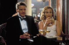 a man in a tuxedo sitting next to a woman with a glass of wine