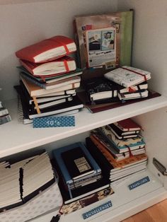 several books are stacked on top of each other in a bookcase, and one is open