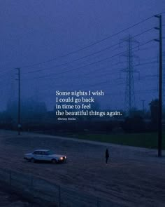 a car driving down a road at night with a person standing in the middle of it