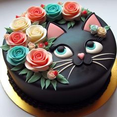 a cake decorated with flowers and a cat's face