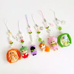 a group of small key chains with cartoon characters attached to them, sitting on a white surface