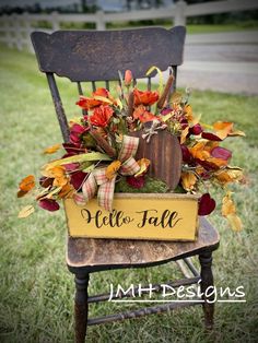 a chair with a sign that says hello fall on it and flowers in the back