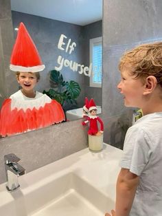 a young boy looking at an elf in the mirror