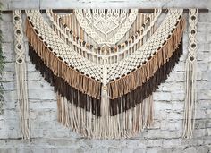 a white brick wall with macrami and tassels hanging from it's sides